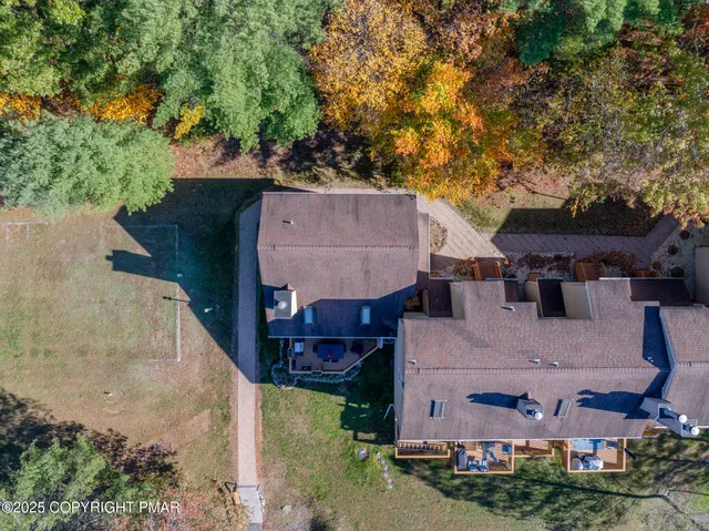 an aerial view of a house with a yard and large tree
