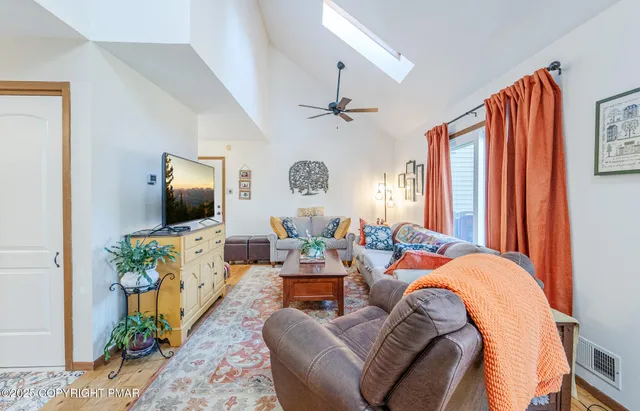 a living room with furniture a flat screen tv and a window