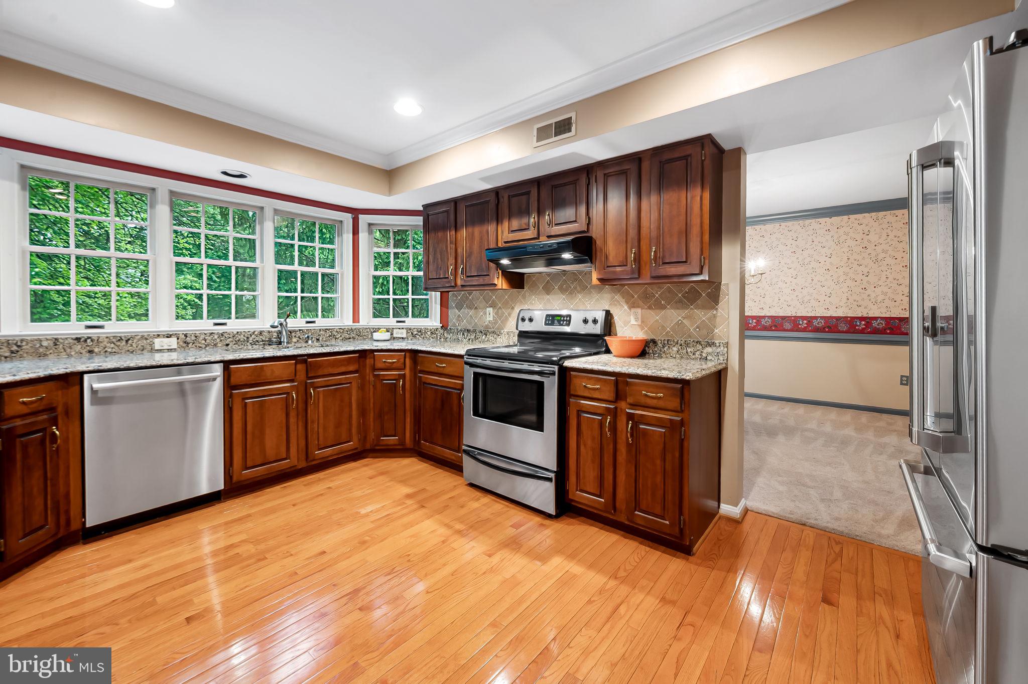 6902 Raven Lane Columbia, MD 21044 - Photo 13 of 47 a kitchen with stainless steel appliances granite countertop a stove a sink and a refrigerator