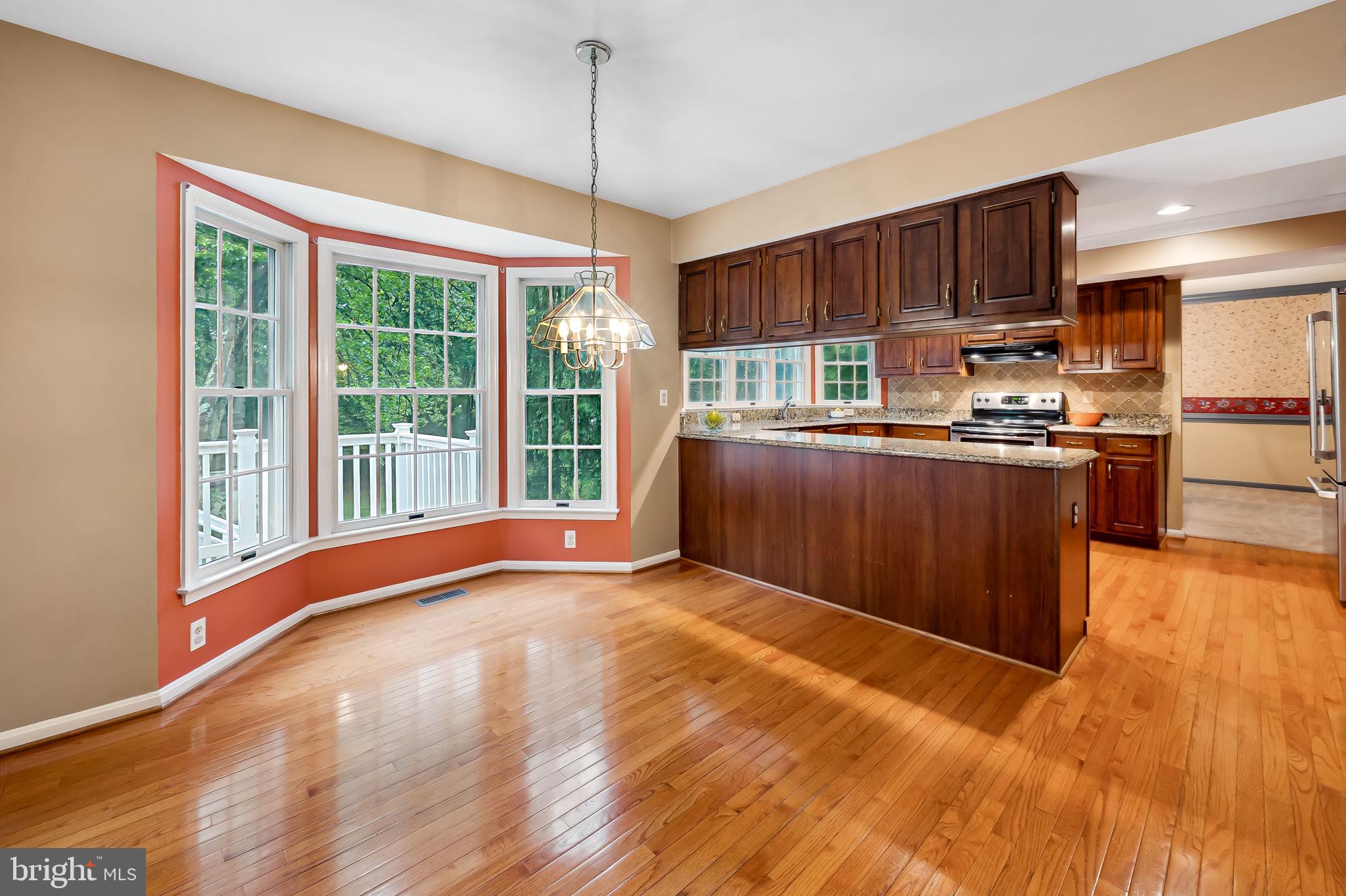 6902 Raven Lane Columbia, MD 21044 - Photo 16 of 47 a view of kitchen with kitchen island wooden floors stainless steel appliances and window