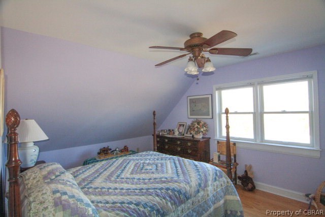 271 Burnt Wharf Road Lancaster, VA 22503 - Photo 17 of 35 a bedroom with a bed and a chandelier