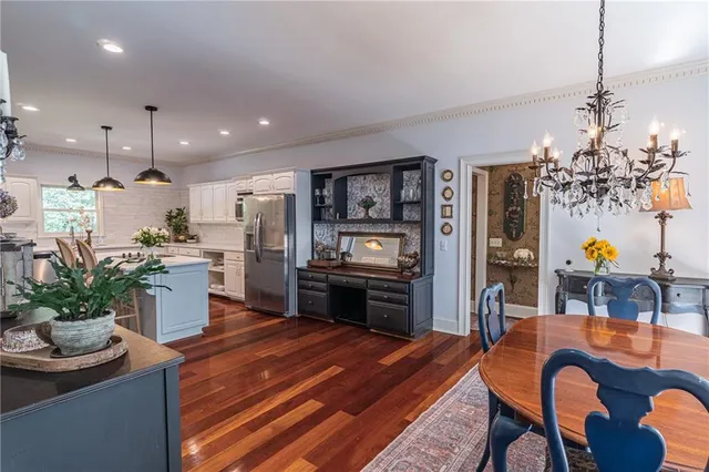 a kitchen with stainless steel appliances kitchen island granite countertop a refrigerator a stove a sink dishwasher and a dining table with the kitchen view