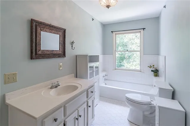 a view of a backyard with table and chairs potted plants and large tree