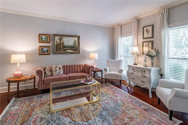 a living room with furniture a lamp paintings and a window