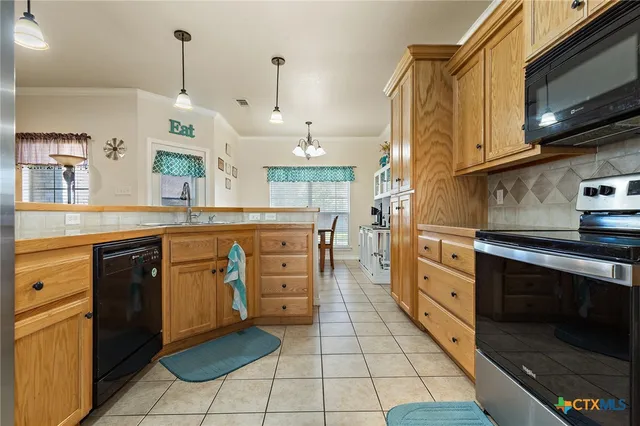 a kitchen with stainless steel appliances granite countertop a sink and a stove