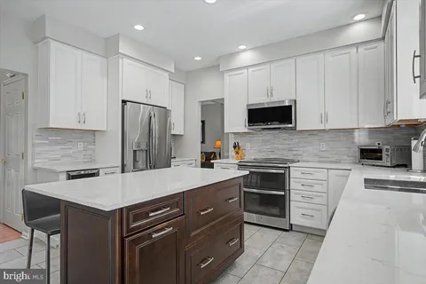 a kitchen with a refrigerator and a stove top oven