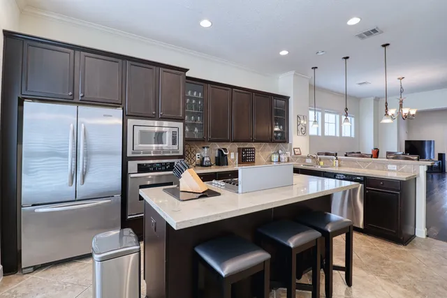 a kitchen with a refrigerator a stove a sink and a microwave