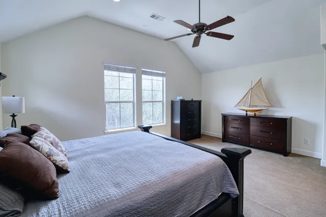 a bedroom with a bed and a ceiling fan
