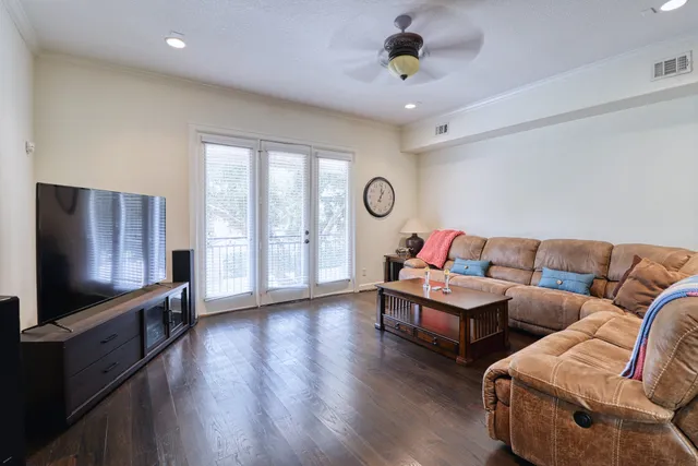 a living room with furniture flat screen tv and wooden floor