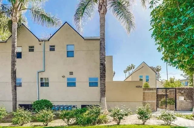 a view of house with a yard and potted plants