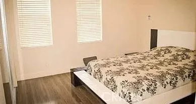 a bed sitting in a bedroom next to a window