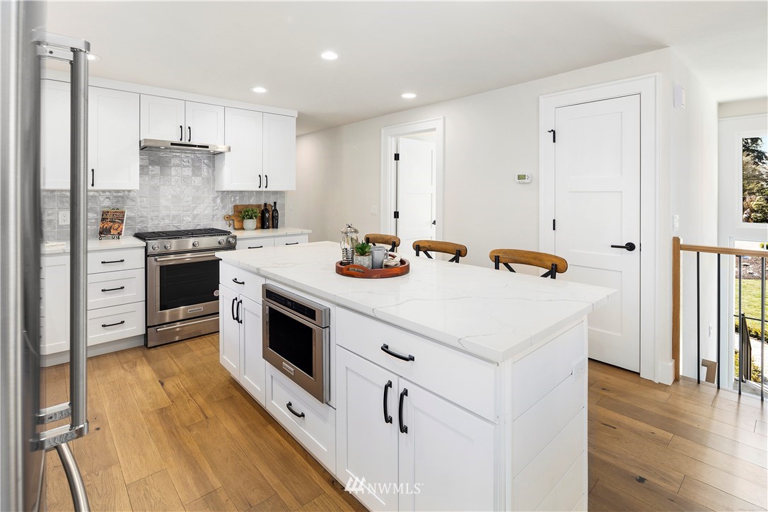 12106 Southeast 26th Street Bellevue, WA 98005 - Photo 7 of 32 a kitchen with stainless steel appliances white cabinets and wooden floor