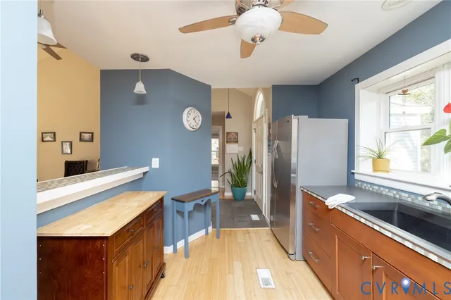 a large kitchen with a large counter top space a sink stainless steel appliances and cabinets