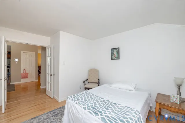 a bedroom with a bed and wooden floor