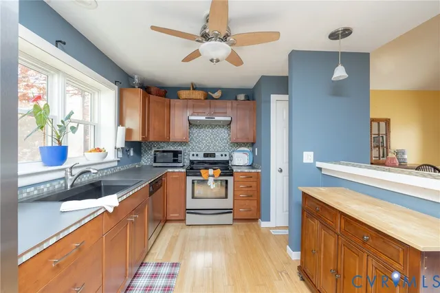 a kitchen with stainless steel appliances granite countertop a sink stove and refrigerator