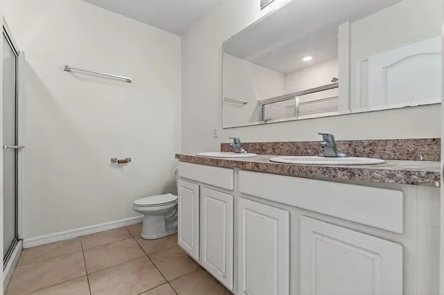 a bathroom with a granite countertop toilet and a sink