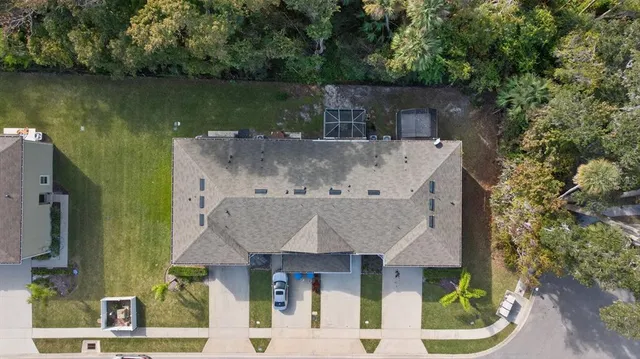 an aerial view of a house with a garden and lake view