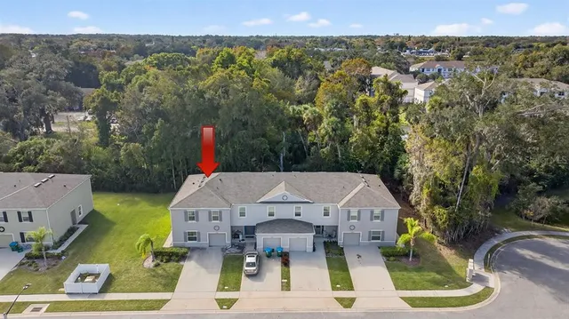 an aerial view of a house with swimming pool and yard
