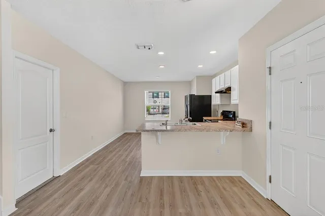 a living room with hard wood floors and a fireplace
