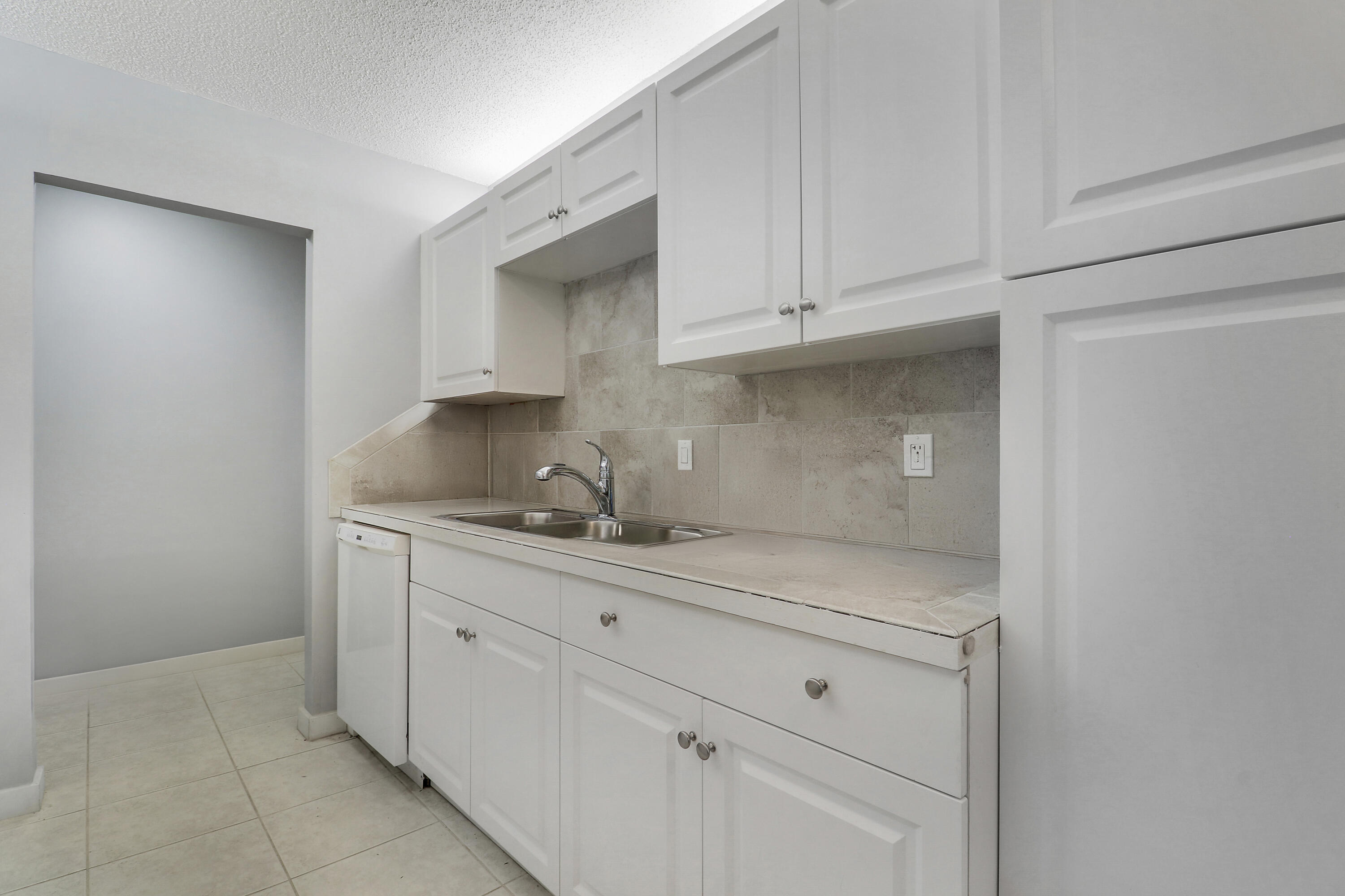 150 Pineview Road, Unit C4 Jupiter, FL 33469 - Photo 8 of 18 a kitchen with white cabinets