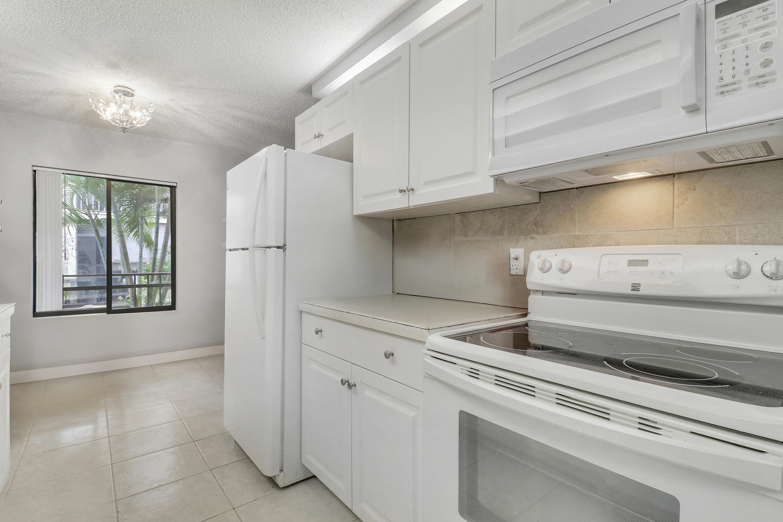 150 Pineview Road, Unit C4 Jupiter, FL 33469 - Photo 9 of 18 a view of kitchen cabinets and refrigerator