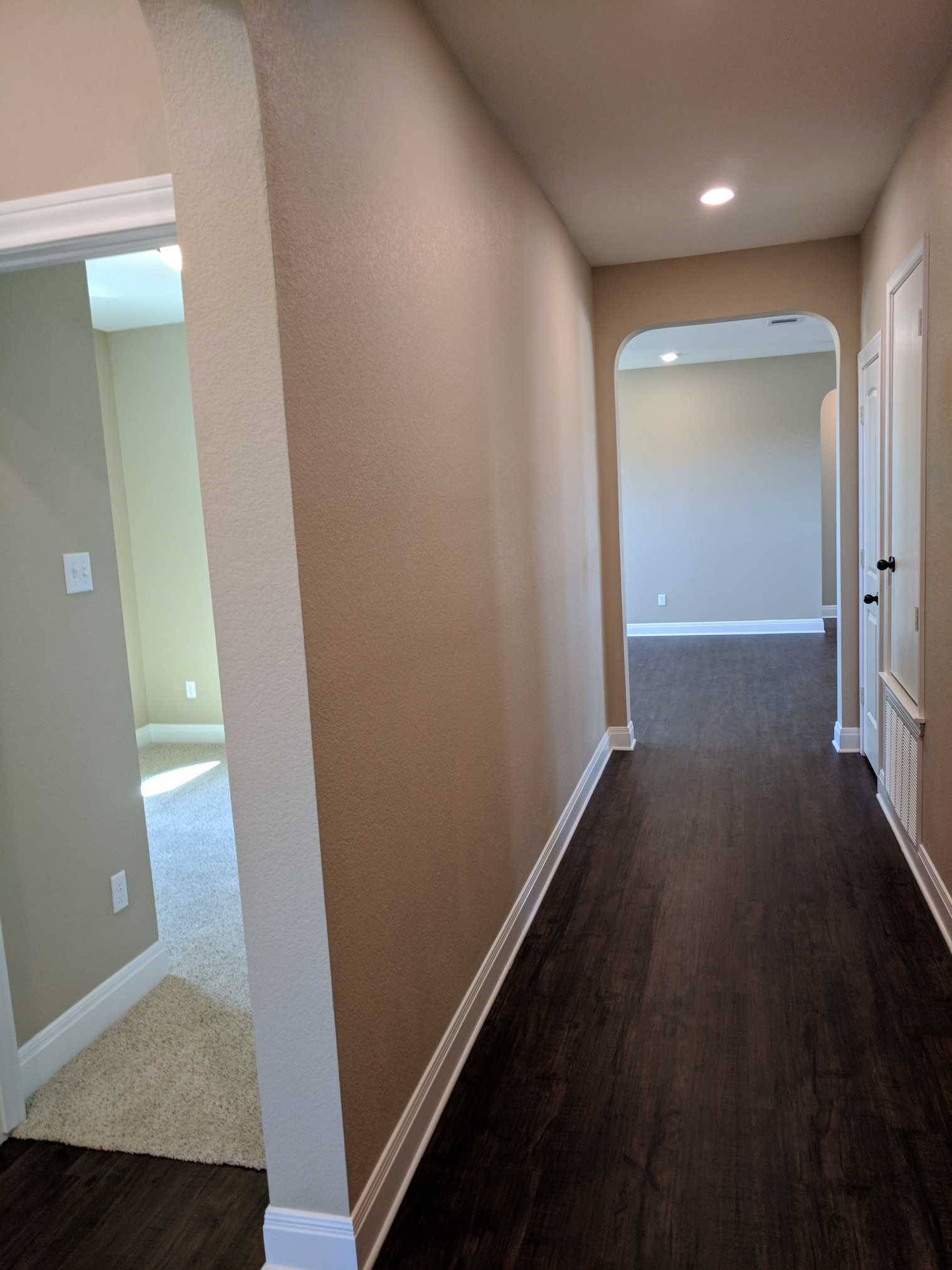 2471 Sunrise Road, Unit 8 Round Rock, TX 78664 - Photo 7 of 13 Inviting hallway featuring wood-finish flooring, neutral-toned walls, recessed lighting, and arched doorways