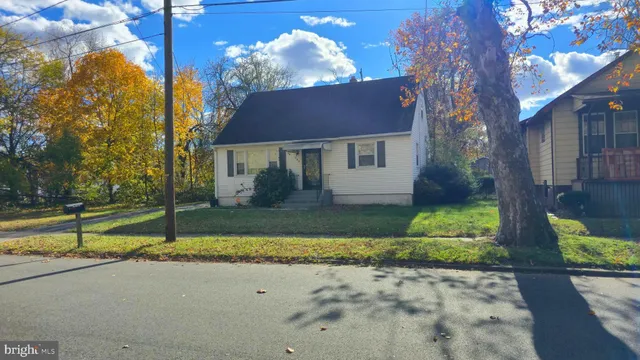 a view of a house with a yard and large tree