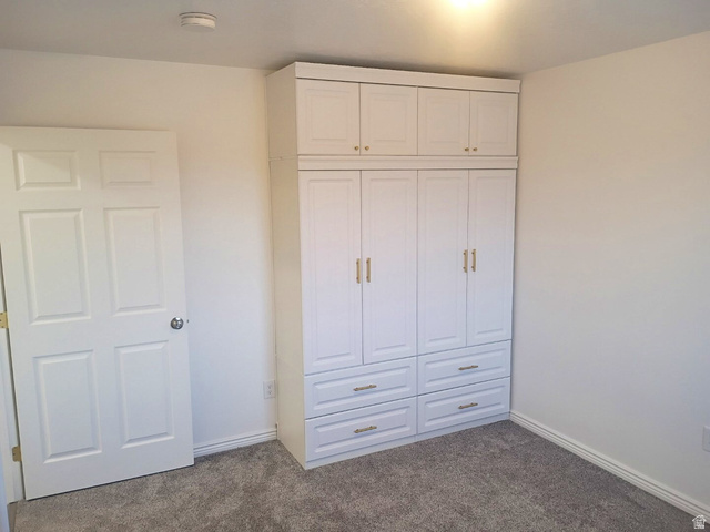 1510 South Lawrence Road Huntington, UT 84528 - Photo 8 of 16 Built-in white cabinetry with gold-finish hardware and integrated drawers, light gray carpeting, and white baseboards