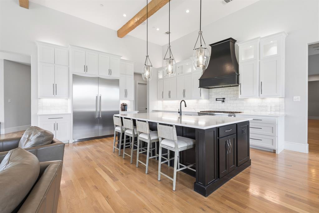 1285 Rimrock Drive Lucas, TX 75002 - Photo 12 of 37 a kitchen with stainless steel appliances granite countertop a sink a stove a dining table and chairs with wooden floor