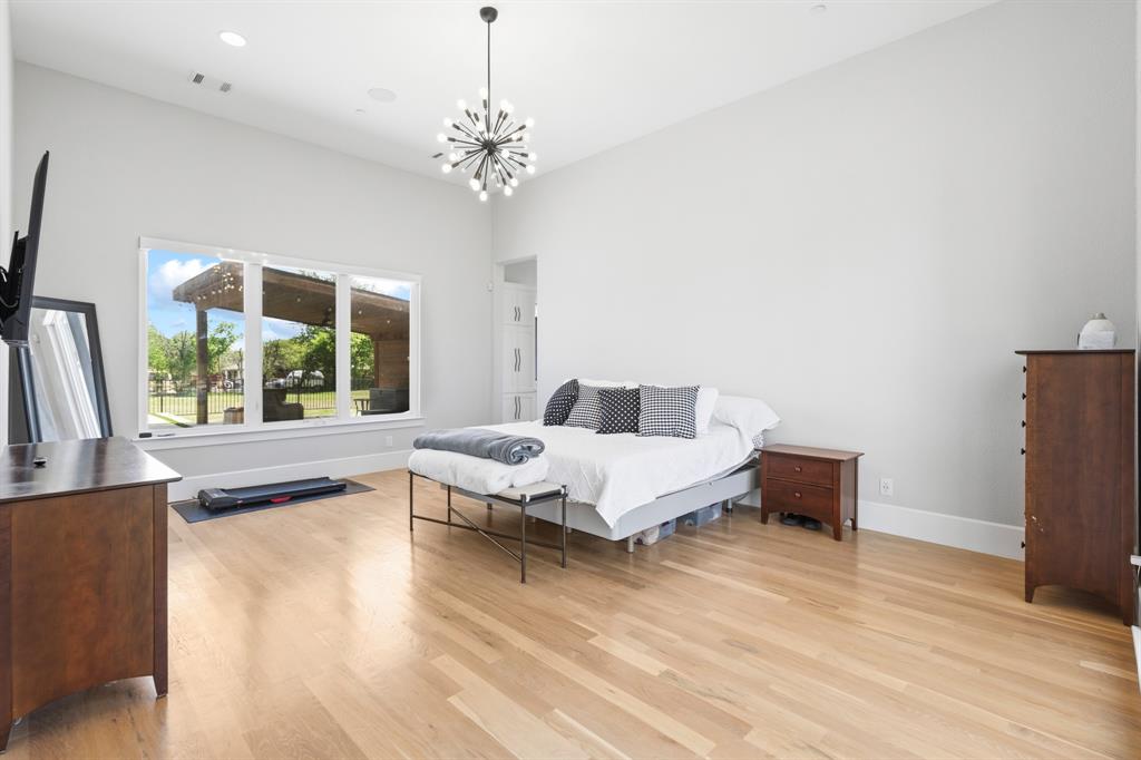 1285 Rimrock Drive Lucas, TX 75002 - Photo 21 of 37 a spacious bedroom with a bed and a chandelier