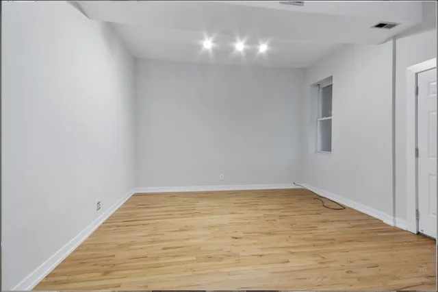 a view of an empty room with wooden floor