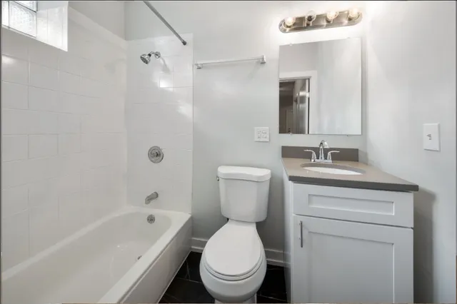 a bathroom with a toilet a sink a mirror and bathtub