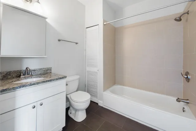 a bathroom with a granite countertop sink toilet and shower