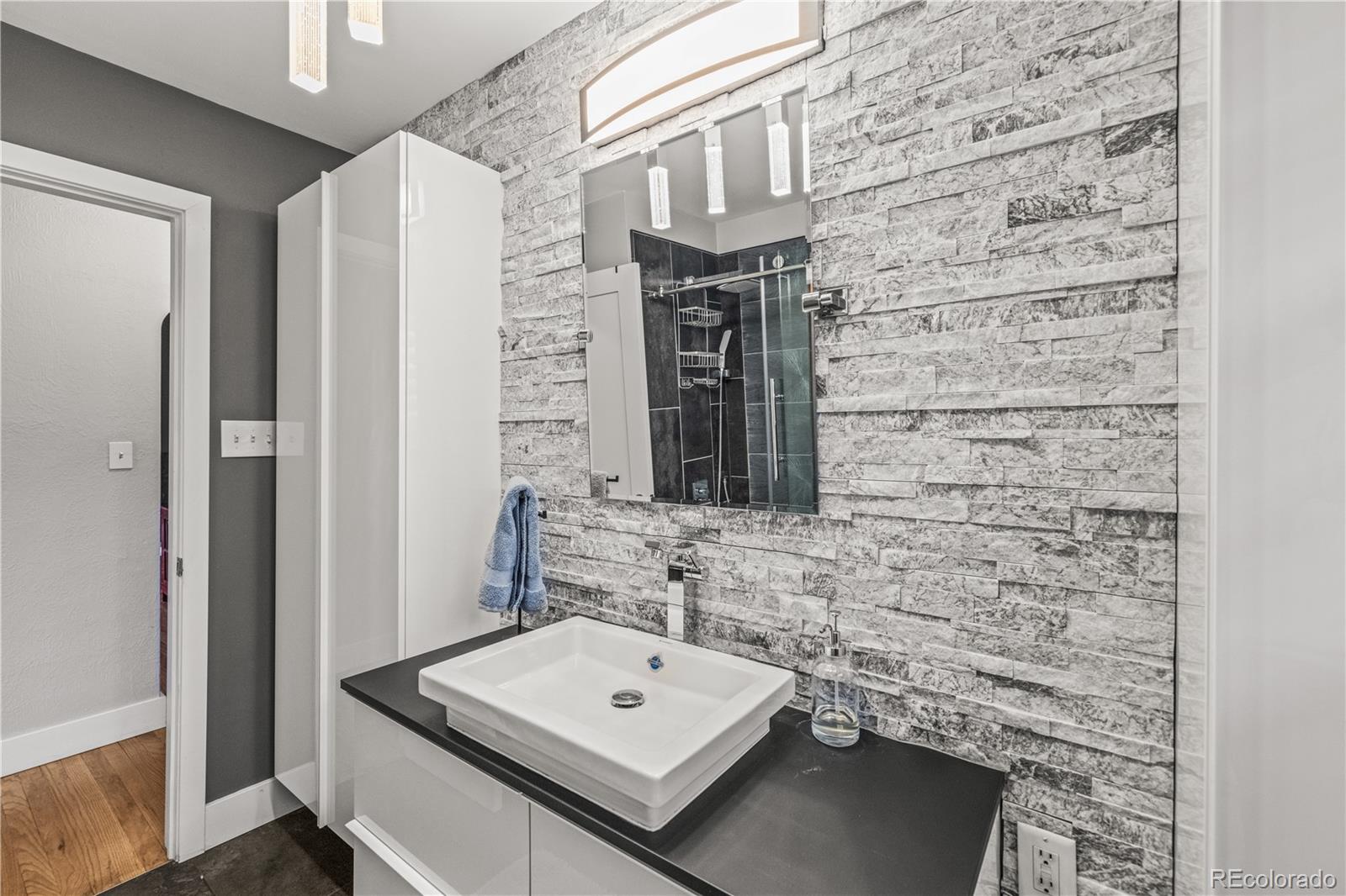 7005 West 44th Avenue Wheat Ridge, CO 80033 - Photo 18 of 37 a bathroom with a sink and a mirror