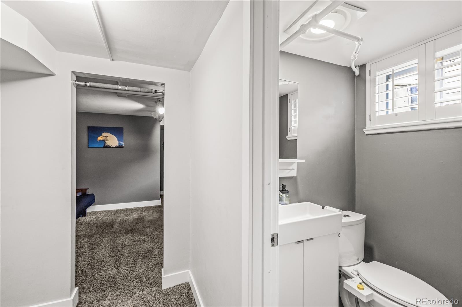 7005 West 44th Avenue Wheat Ridge, CO 80033 - Photo 30 of 37 a bathroom with a sink a toilet and shower