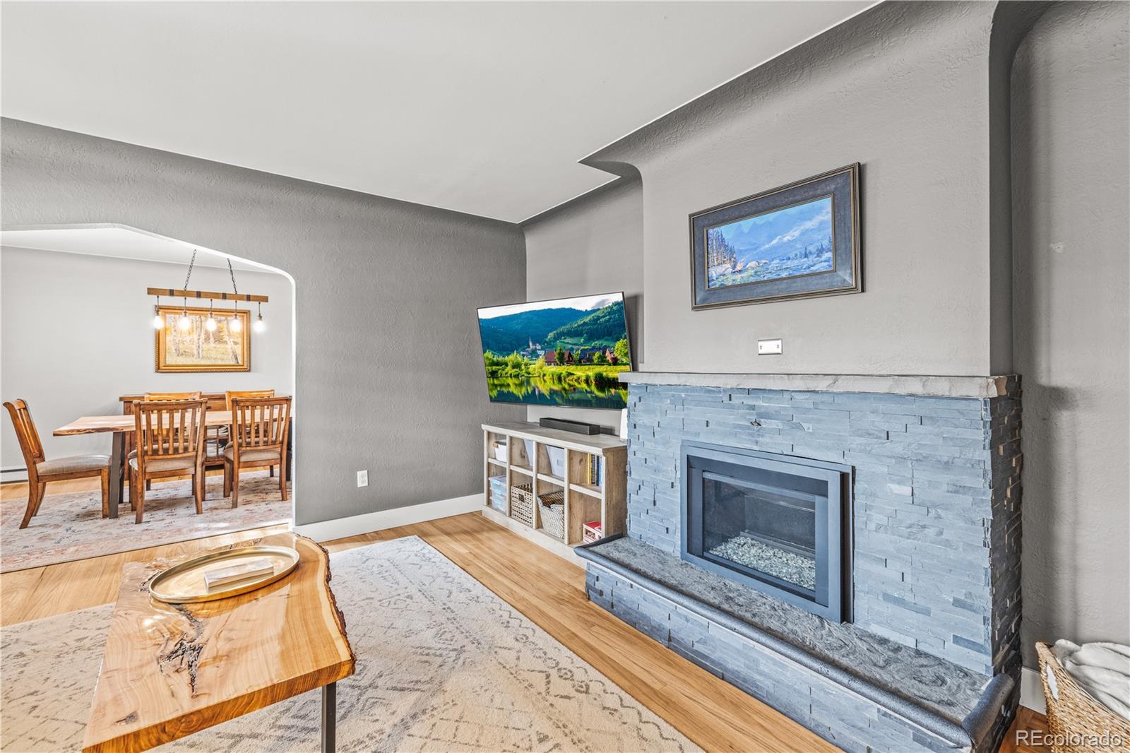 7005 West 44th Avenue Wheat Ridge, CO 80033 - Photo 8 of 37 a living room with furniture a flat screen tv and a fireplace