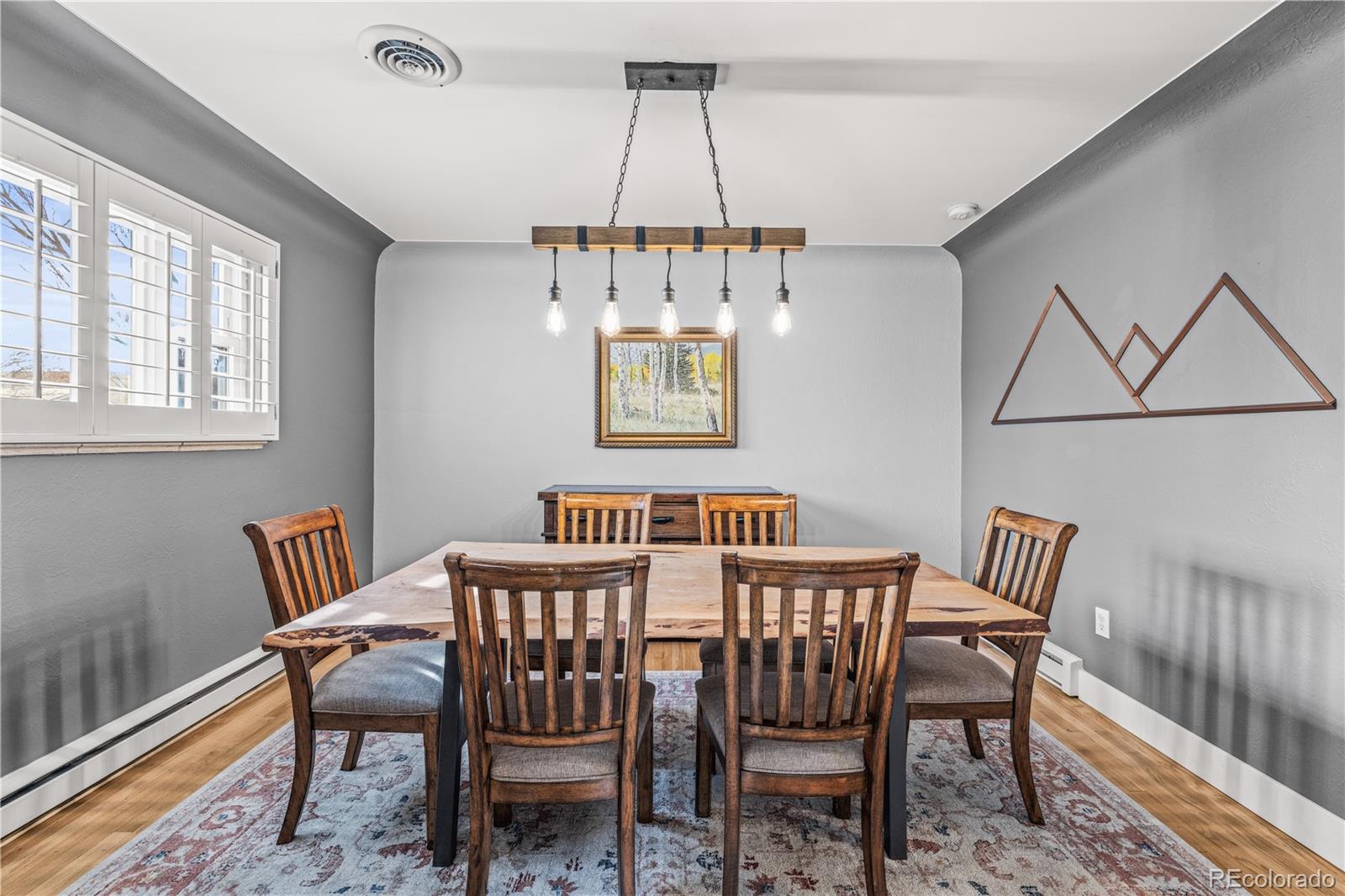 7005 West 44th Avenue Wheat Ridge, CO 80033 - Photo 9 of 37 a view of a dining room with furniture window and wooden floor