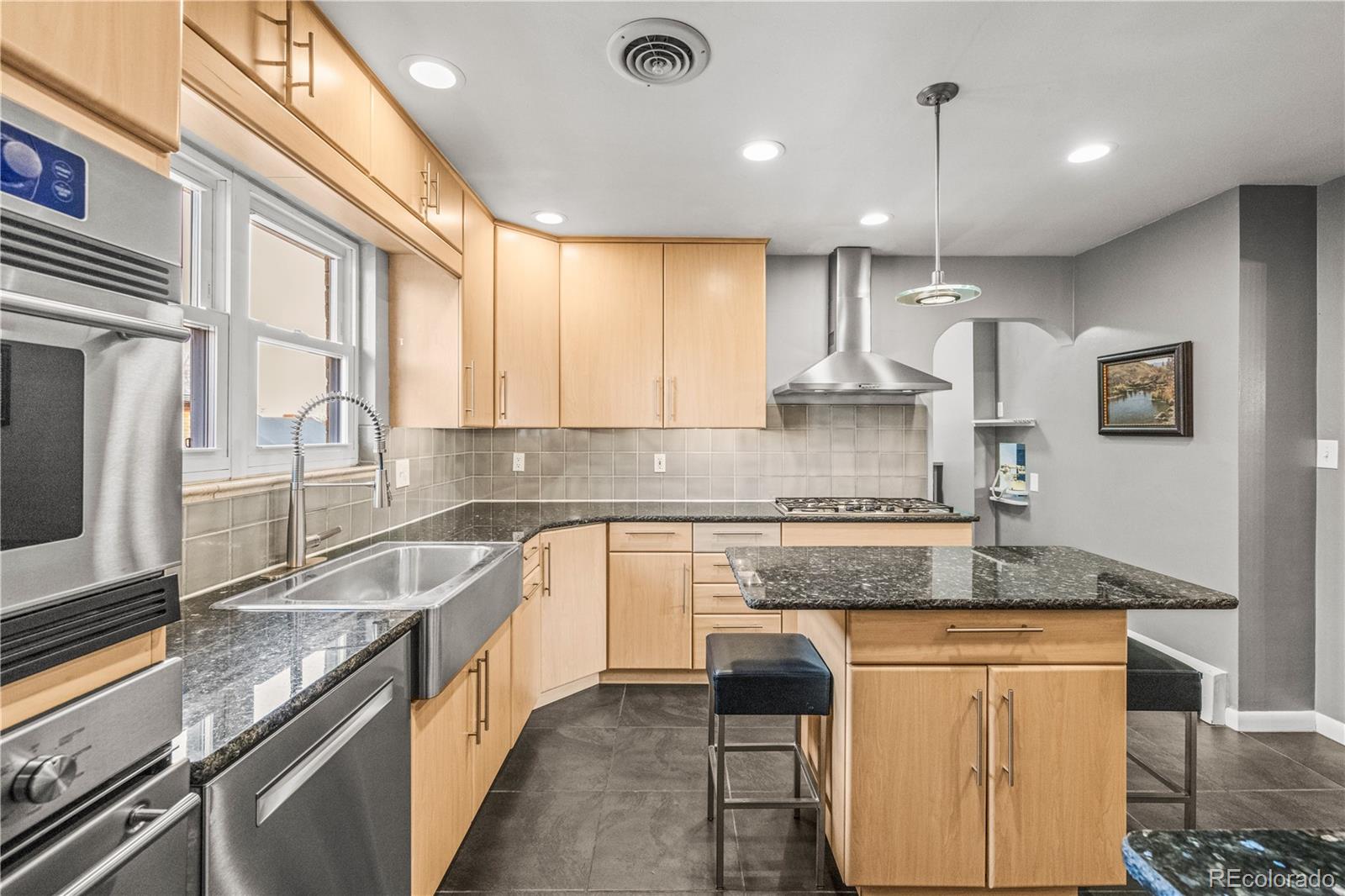 7005 West 44th Avenue Wheat Ridge, CO 80033 - Photo 10 of 37 a kitchen with stainless steel appliances granite countertop a sink stove and refrigerator