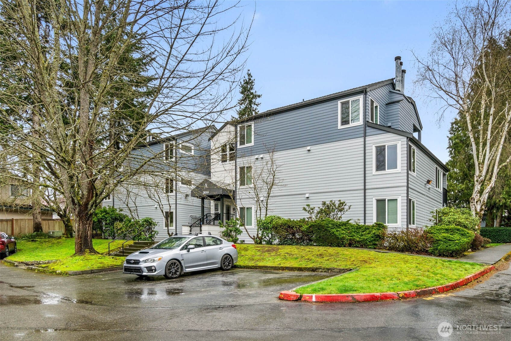 20318 Bothell Everett Highway, Unit A204 Bothell, WA 98012 - Photo 4 of 35 a front view of a house with a yard and garage