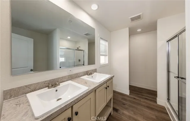 a bathroom with a sink double vanity granite tub shower and a mirror