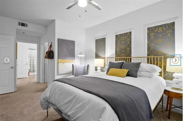 a bedroom with a bed couches and potted plant