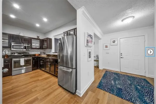 a kitchen with stainless steel appliances granite countertop a refrigerator and a stove
