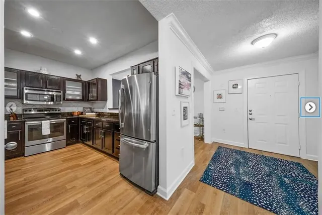 a kitchen with stainless steel appliances granite countertop a refrigerator and a stove