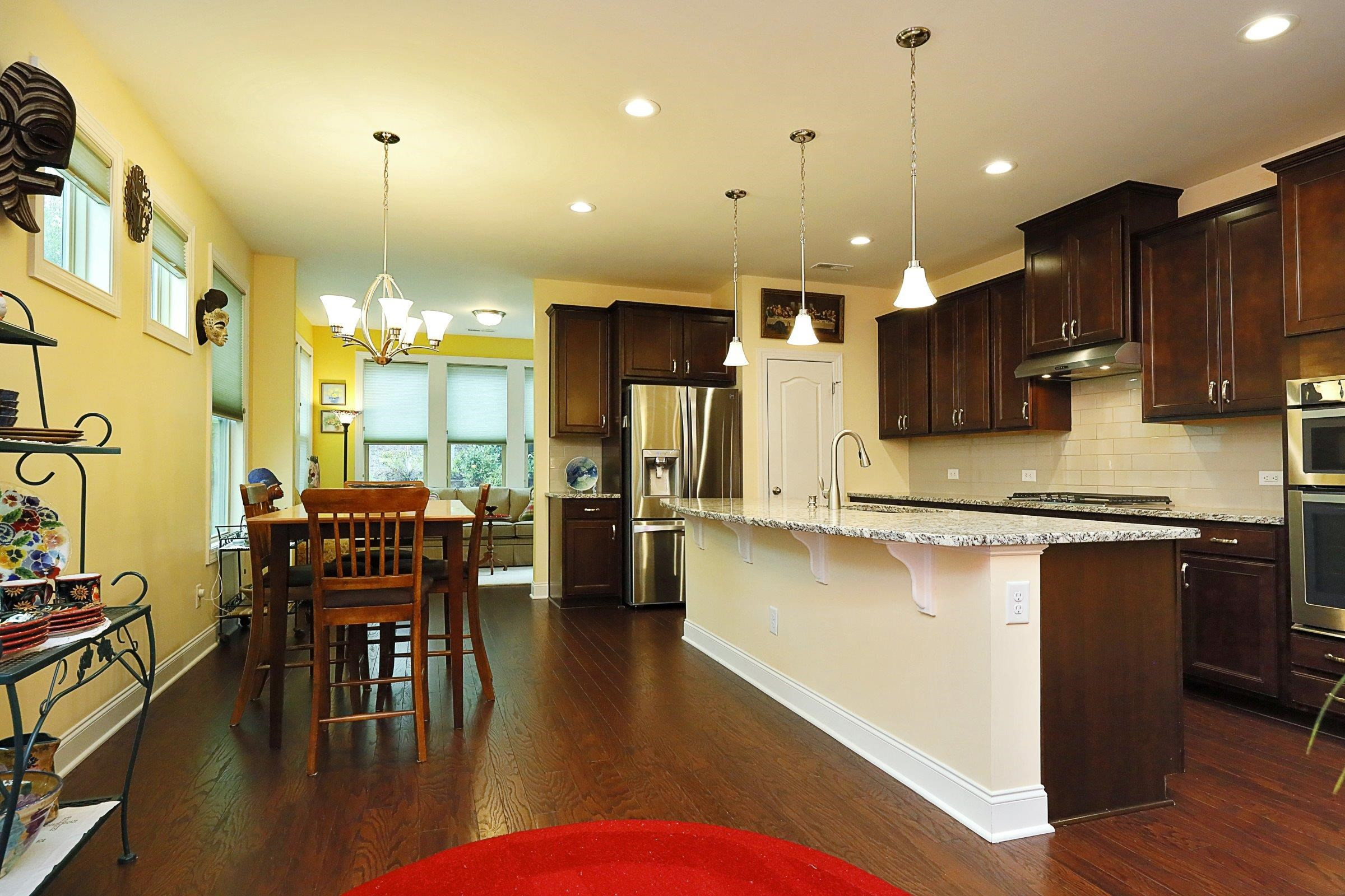1241 Catch Fly Lane Durham, NC 27713 - Photo 6 of 44 a kitchen with stainless steel appliances kitchen island granite countertop a stove a refrigerator a kitchen island a dining table and chairs with wooden floor