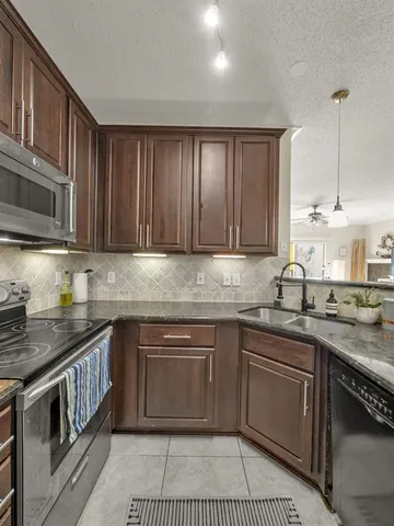 a kitchen with kitchen island a counter top space cabinets and stainless steel appliances
