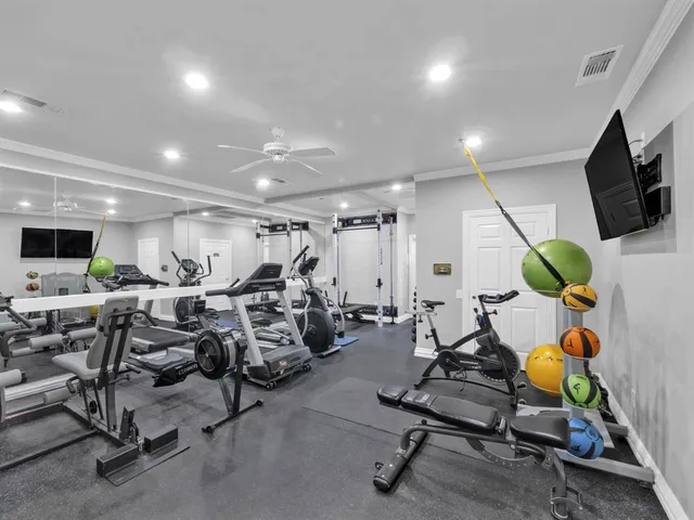 a room with gym equipment and a flat screen tv