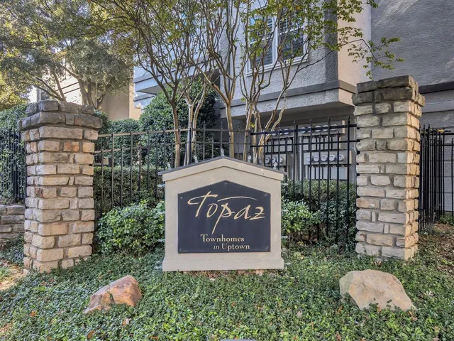 a sign board with buildings in the background
