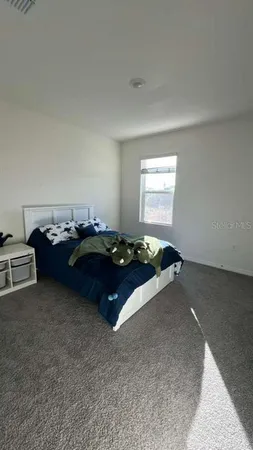 a bed sitting in a room next to a window