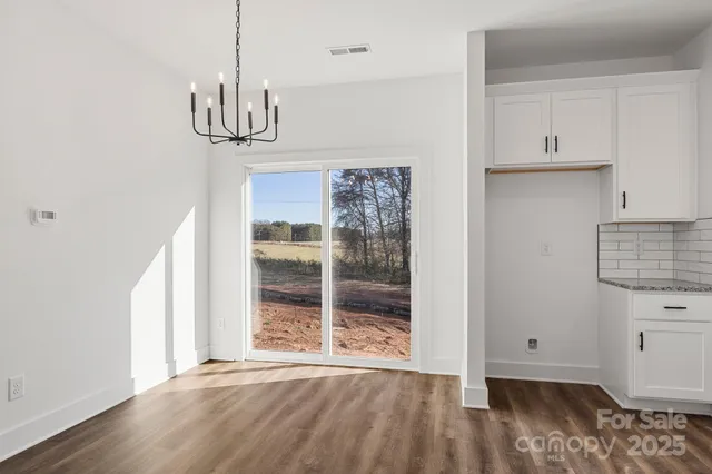 a view of empty room with wooden floor and window