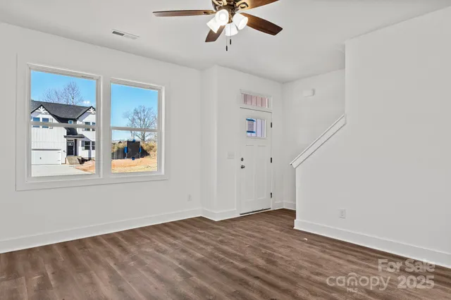 a view of a livingroom with wooden floor and a ceiling fan